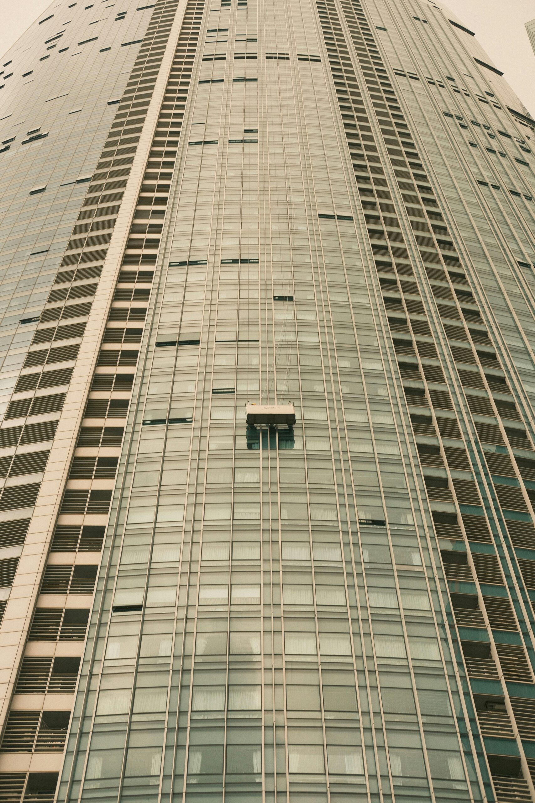 Cleaning Buildings A skyscraper facade with a window cleaning platform in a modern architectural setting.